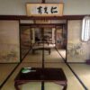 襖に山水画が描かれた広い和室と複数の座卓