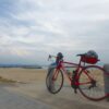 人のいない海岸沿いに停めた赤いロードバイク