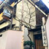 格子戸と提灯、縦型の看板がある趣のある和風建物の外観