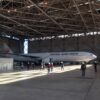 格納庫に駐機したJAL機、ヘルメット姿の見学者たち
