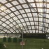 屋根付き練習場のドーム型天井とグラウンドを見学する様子