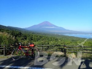 富士山と山中湖の絶景を背にした赤いロードバイク