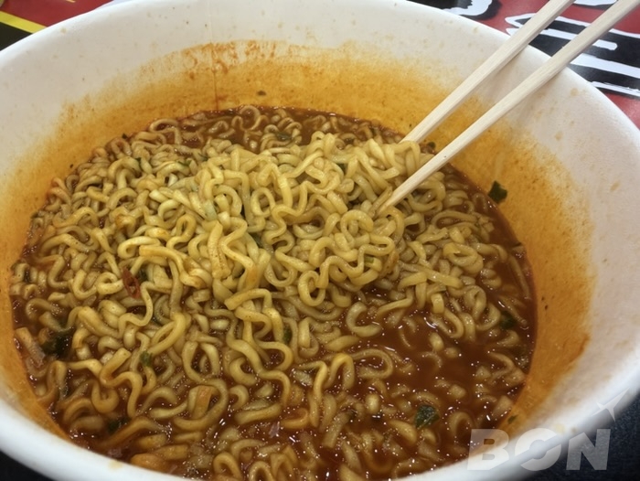 Kラーメンコンビニ イートインコーナーで韓国インスタントラーメンを食べる様子