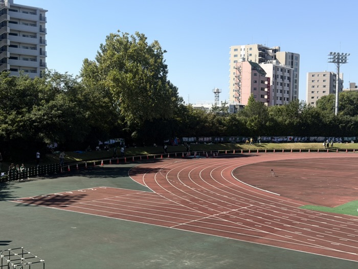 陸上トラック越しに見た、横断幕が並ぶホーム側ゴール裏の芝生席